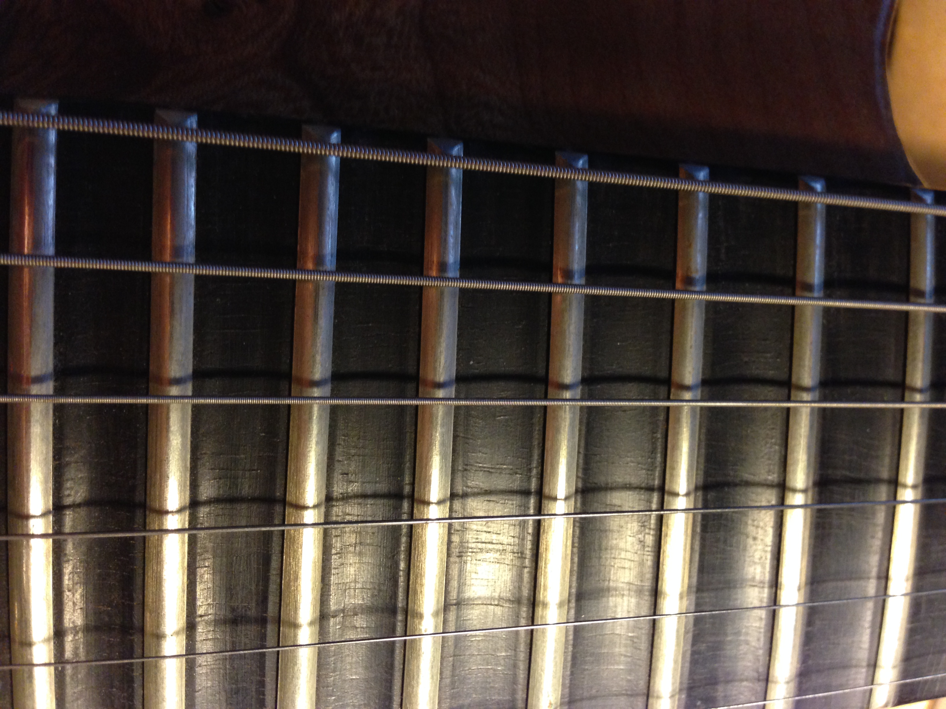 Scalloped ebony fingerboard, gradual increase from the octave to the 24th fret.
